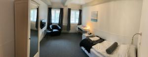 カロンボーにあるHotel Ole Lunds Gaardのベッド、デスク、椅子が備わる客室です。
