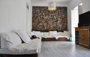 a living room with a couch and a stone wall at Aloha Beach House H in Cascais