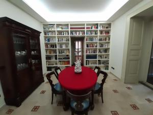 a dining room with a red table and chairs and bookshelves at L'Arnia in Naples