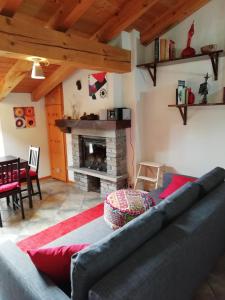 uma sala de estar com um sofá e uma lareira em Mansarda em Champorcher
