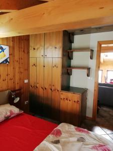 1 dormitorio con 1 cama y armario de madera en Mansarda en Champorcher