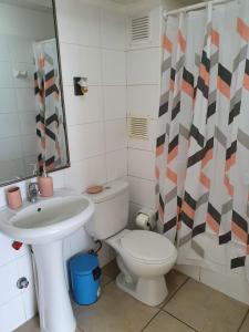 a bathroom with a sink and a toilet and a mirror at Apartamento NEO vista al mar in Iquique