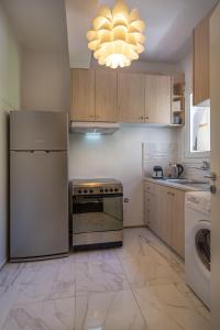 uma cozinha com um frigorífico de aço inoxidável e uma máquina de lavar louça em Demetra - Koukaki center apartment em Atenas