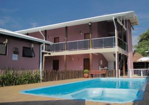 a house with a swimming pool in front of a building at Pousada Parapuã in Caraguatatuba