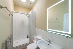 a bathroom with a shower and a sink and a mirror at Kings Stables, Grassmarket in Edinburgh