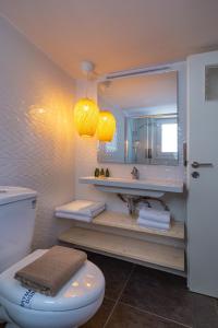 W łazience znajduje się toaleta, umywalka i lustro. w obiekcie Demetra - Koukaki center apartment w Atenach