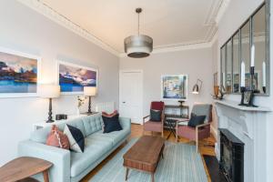 a living room with a blue couch and a fireplace at Raeburn Place in Edinburgh