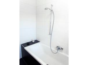 a bathroom with a tub and a shower at Ferienhaus Minnet, 15169 in Leer