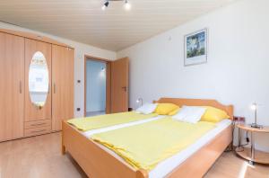 een slaapkamer met een groot bed met gele lakens bij Apartments Ankica Blue in Peroj