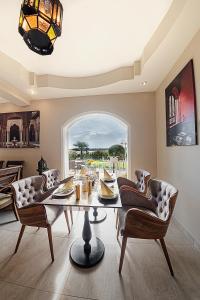 a dining room with a table and chairs and a window at Casablanca Panzió in Tata