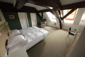 una camera con un letto bianco e due sedie di Auberge de Prangins a Prangins