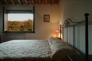 a bedroom with a bed and a window with a view at Agriturismo Quattro Pini in Castagneto Carducci