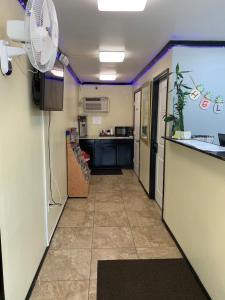 a hallway with a kitchen and a fan at Masters Inn in Seffner