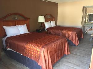 una camera d'albergo con due letti e una lampada di Masters Inn a Seffner