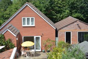 a small red brick house with a yellow umbrella at glastonbury town garden house in Glastonbury