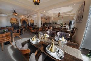a dining room with tables and chairs and a restaurant at Casablanca Panzió in Tata