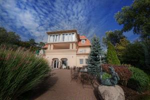 a large house with a statue in front of it at Casablanca Panzió in Tata
