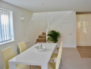 a white dining room with a white table and chairs at glastonbury town garden house in Glastonbury