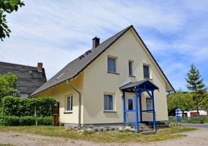 a small yellow house with a blue door at Ferienwohnungen Familie Looks in Klein Zicker