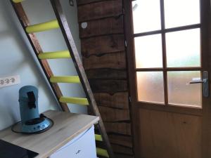 uma escada em espiral num quarto com uma porta em Cabane du hérisson em La Capelle-en-Thiérache