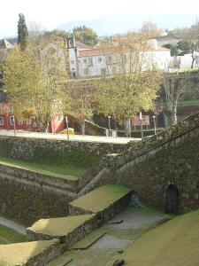 un mur en pierre avec des escaliers dans un parc dans l'établissement Hotel Convento dos Capuchos, à Monção