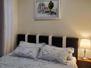 a bedroom with a bed with a black and white headboard at Jen's Paranaque City Apartment in Manila