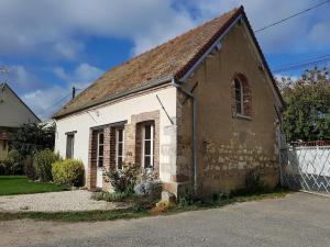 an old brick and white building with a fence at La ferme de flo' in Évry