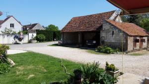 a small stone building with a garage in a yard at La ferme de flo' in Évry