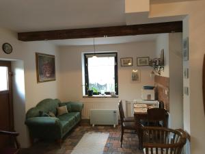 庫特納霍拉的住宿－Apartmán Vrchlice，客厅配有绿色沙发和桌子