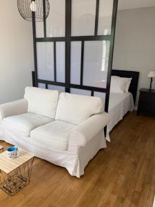 a living room with a white couch and a bed at VILLA CATHY in Dives-sur-Mer