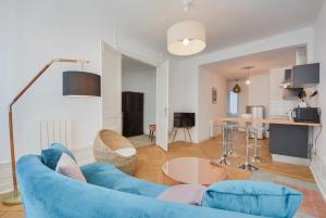 a living room with a blue couch and a table at Le superbe des Dominicains in Nancy