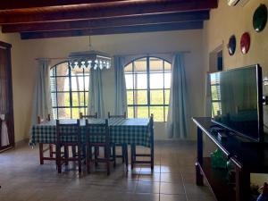 a dining room with a table and chairs and a television at Puesto Las Totoras in San Antonio de Areco