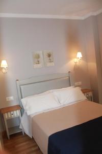 a hotel room with a white bed and white comforter at Hotel Torre del Oro in La Rinconada