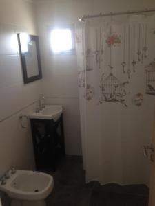 a bathroom with a sink and a toilet and a shower curtain at Temporal Eva in San Justo