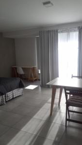 a bedroom with a bed and a table and a window at Temporal Eva in San Justo