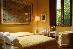 a hotel room with two beds and a table at Villa Spalletti Trivelli - Small Luxury Hotels of the World in Rome