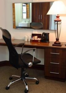 
a desk with a chair and a lamp at Premier Splendid Inn Pinetown in Pinetown
