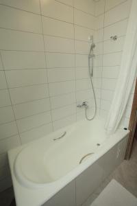 a bathroom with a shower with a white tub at Novie Gorki in Korolëv