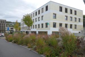 ein weißes Gebäude mit Pflanzen davor in der Unterkunft Partner Hotel AG Zofingen in Zofingen