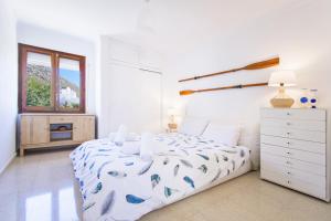 una camera bianca con un letto e una finestra di Apartment El Faro a Port de Pollença