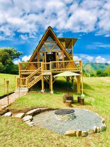 a log cabin with a fire pit in front of it at Glamping La Herradura in Santa Rosa de Cabal