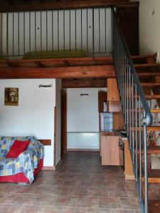 a living room with a bed and a staircase at Agriturismo le cascine in Castel di Tora
