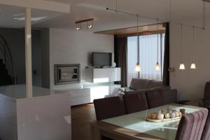 een keuken en een woonkamer met een tafel en een televisie bij Villa Georges met tuin en sauna in Koksijde
