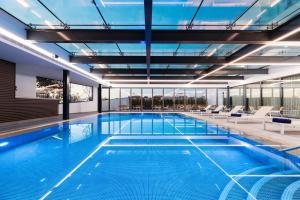 a swimming pool with lounge chairs and a large building at Eurostars Matosinhos in Matosinhos