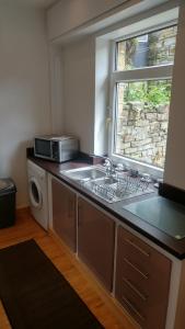 a kitchen with a sink and a microwave at The Comfy House in Huddersfield