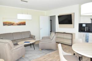 ein Wohnzimmer mit einem Sofa und einem Tisch in der Unterkunft Avalon Ferienwohnungen Bellevue in Fehmarn