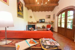 ein Wohnzimmer mit einem roten Sofa und einem Tisch in der Unterkunft La Capannella del Cinema in Capannori