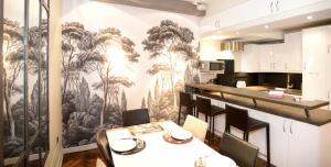 une cuisine et une salle à manger avec une fresque murale d'arbres dans l'établissement Appart' Herbouville, à Lyon