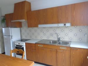 a kitchen with wooden cabinets and a sink at GITE DES BOULEAUX in Maîche