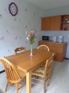 a wooden table with a vase of flowers on it at GITE DES BOULEAUX in Maîche